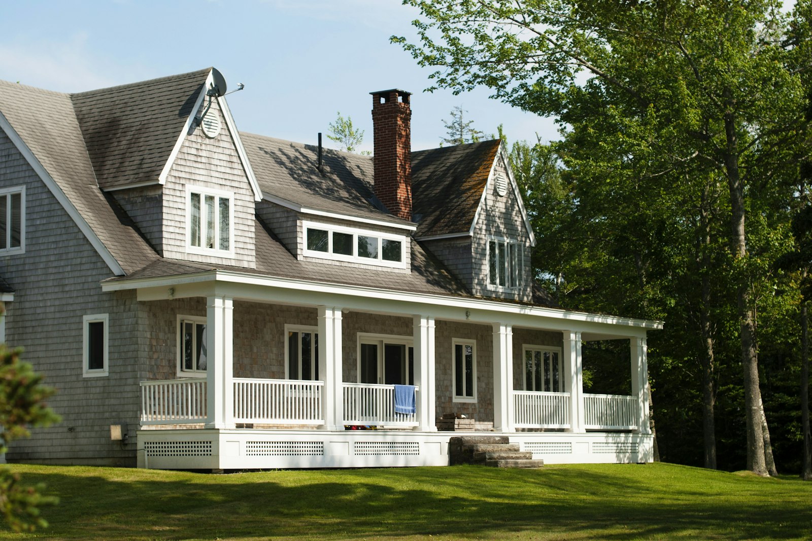 White and brown wooden house near green trees